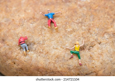 Miniature Man And Woman Doing Rock Climbing Close Up 