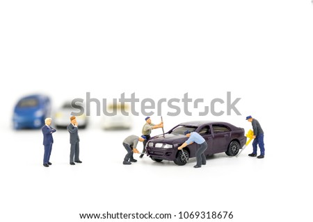 Miniature mechanics repairing toy car,concept of the workshop