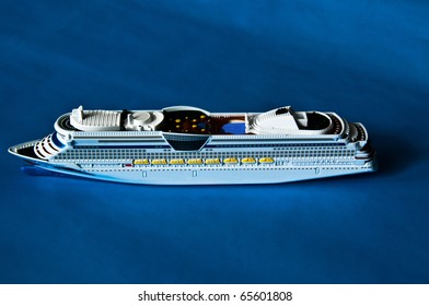 Miniature Model Of A Cruise Ship (childrenÂ´s Toy) On Blue Paper