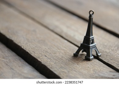Miniature model of the Eiffel Tower on a vintage wooden background.