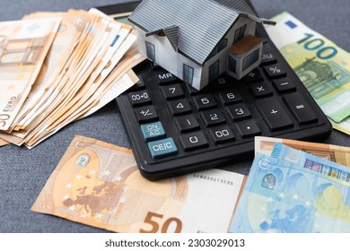 Miniature model of houses on stacked euro banknotes, on isolated white background. Real estate investment concept. Saving money for future retirement. - Powered by Shutterstock