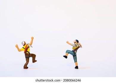 Miniature mountain climber in action, back view, white background, copy space - Shutterstock ID 2080066246