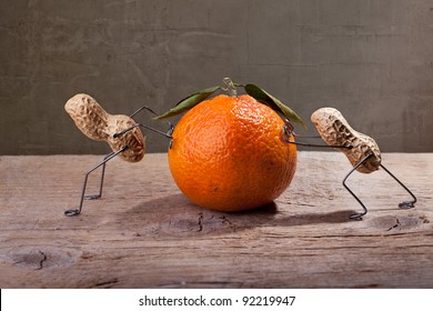 Miniature with Peanut People working against each other, failing to move the orange - Powered by Shutterstock