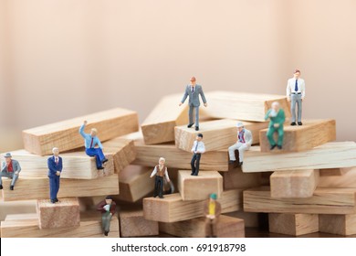 Miniature people: Business man standing on wood block using as background Choice of the best suited employee, HR, HRM, HRD, job recruiter concepts.