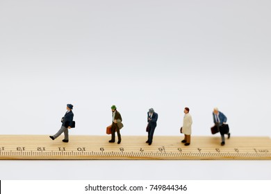 Miniature people: Business team walking on ruler. - Powered by Shutterstock