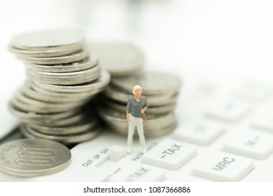 Miniature people: Business woman standing with stack of coins on tax calculator using as background money growth up, saving, financial, business concept.