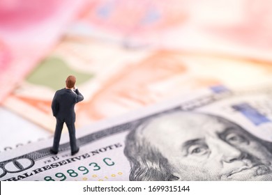 Miniature people : Businessman standing on the banknote (US dollars and Singapore dollars) with banknote background and think on the how to growth money. Money, business and finance concept - Shutterstock ID 1699315144