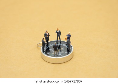 Miniature people businessmen analyze standing on compass as background strategy concept and Business concept with copy space and white space. - Powered by Shutterstock