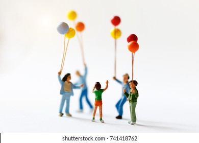Miniature people children holding balloon  with sunlight, happy family day concept. - Shutterstock ID 741418762