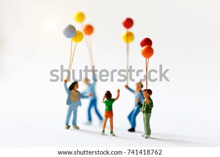 Miniature people children holding balloon  with sunlight, happy family day concept.