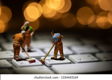 Miniature People Cleaning White Keyboard Computer.