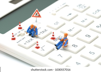 Miniature People Construction Worker Keypad TAX Button For Tax Calculation. Easy To Calculate. On White Calculator On White Background Using As Background Business Concept And With Copy Space. 