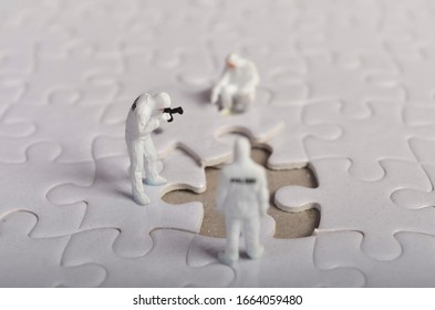 Miniature People ; Crime Scene Investigation With Missing Jigsaw Puzzle. Selective Focus.