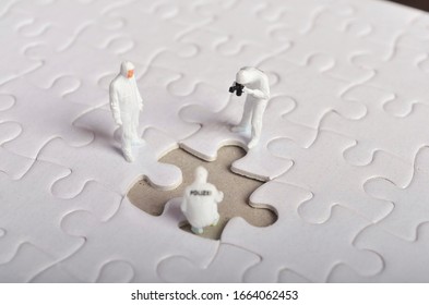 Miniature People ; Crime Scene Investigation With Missing Jigsaw Puzzle. Selective Focus.