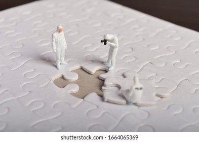 Miniature People ; Crime Scene Investigation With Missing Jigsaw Puzzle. Selective Focus.