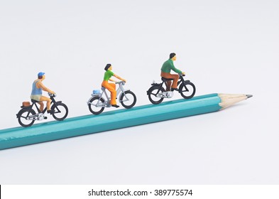 Miniature People Cycling On Pencil