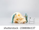 Miniature people Doctor with a giant human skull on a grey background, Science and Medical Concept