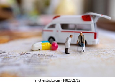 Miniature people : Doctor and patient standing with Capsule and Ambulance. Healthcare and medical concepts.