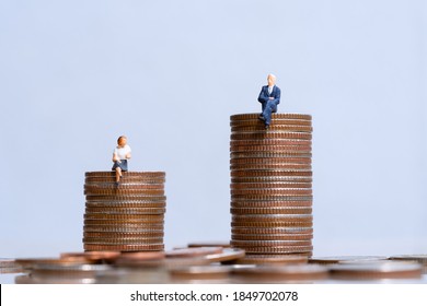 Miniature People: Elderly People Sitting On Coins Stack. Social Security Income And Pensions. Money Saving And Investment. Inequality In Social Class, Ideology, Gender, Racial And Ethnic And Health.