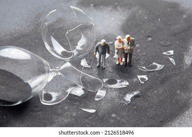 miniature people. elderly people walk near the broken hourglass. loss of life time. crisis of hope and problems of old age