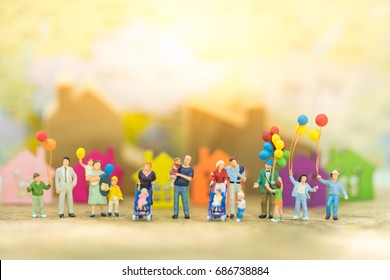 Miniature people, family and children with colorful ballons  standing in front of house. International Day of Families