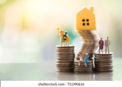 Miniature People: Family Standing On Coins Stacks With  House Model On The Top Stack.  Concepts. Concept For Property Ladder, Mortgage,real Estate Investment, Money, Love And Valentine's Day.