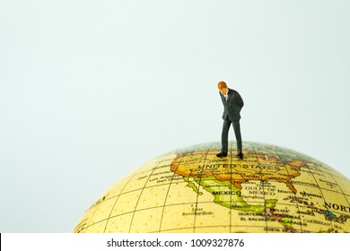 Miniature People Figure Businessman Standing On United States Of America Map On Globe As World Leader Decision Concept.