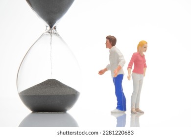miniature people. figures of a man and a woman near the hourglass on a white background. time to talk. communication and relationship building. problems in communication. - Shutterstock ID 2281220683