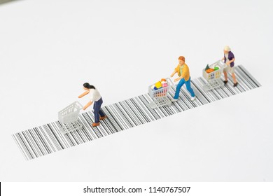 Miniature People Figurine With Grocery In The Shopping Cart Rally On The Bar Code Using As Ecommerce, Consumer Or Buy And Sale In New Technology Channel Concept.