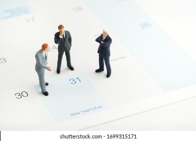 Miniature People : A Group Of Businessmen Standing On The White Calendar And Look At The End Of New Year (31 Dec) With Copy Space. He Plan The New Strategy For Next Year. Business, Finance And Concept