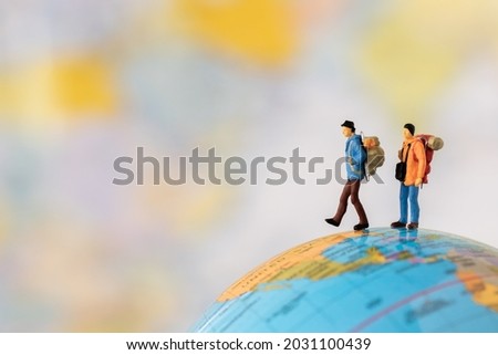 Miniature people Group of young tourist traveler traveling standing on Global world map travel around the world, business trip traveler adviser agency or online world wide marketing new transportation