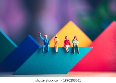 Miniature people, man and woman sitting on colorful wooden block using as business and social concept - Shutterstock ID 1990208861