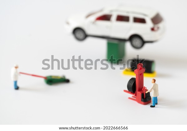 Miniature people Mechanic Labor Team changing car tire\
working in garage automobile service using for Car Automotive\
maintenance repair fixed or replacement Service or Vehicle\
Insurance guarantee 
