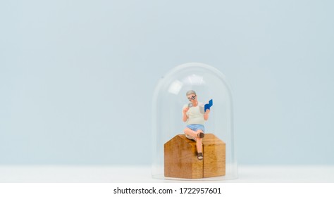 Miniature People : Old Man Reading The Book At Home Under A Glass Dome Cap Stay Home Safe Lives. Stay Home Stay Safe Lockdown From Coronavirus Covid-19 Pandemic Crisis.Healthcare, People, New Normal.