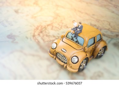 Miniature people on car using as background travel or business concept. - Powered by Shutterstock