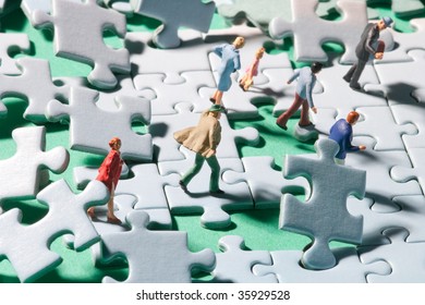 Miniature people on a jigsaw puzzle in windstorm