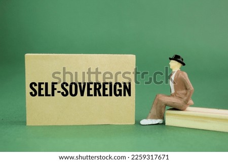 miniature people and paper with the word SELF-SOVEREIGN. the concept of individual freedom