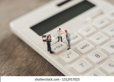 Miniature people Pay queue Annual income (TAX) for the year on calculator. using as background business concept and finance concept with copy space  for your text or  design.