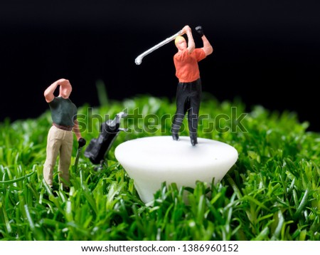miniature people playing golf in a big picture