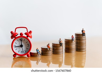 Miniature people: Red alarm clock and elderly people sitting on coins stack. Retirement planning. money saving and Investment. Time counting down for retirement and pension. - Shutterstock ID 1567607860