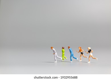 Miniature people Running on gray background and free space for text