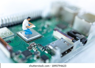 Miniature people searching or checking for bugs and issue on microchip, mainboard of computer. Vulnerability search and security system concept.