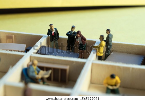 Miniature people separated in office cubicles.Work\
in a sterile office environment. People divided in little boxes.\
Personal space to complete your work. Office politics, romance, or\
drama.
