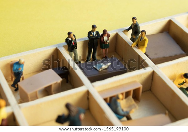 Miniature people separated in office cubicles.Work
in a sterile office environment. People divided in little boxes.
Personal space to complete your work. Office politics, romance, or
drama.