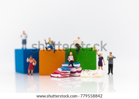 Miniature people: sitting on book and read book for increase knowhow using as learning never ends, education concept.