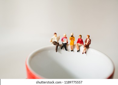 Miniature people  sitting on cup of coffee using as business meeting and social concept - Powered by Shutterstock