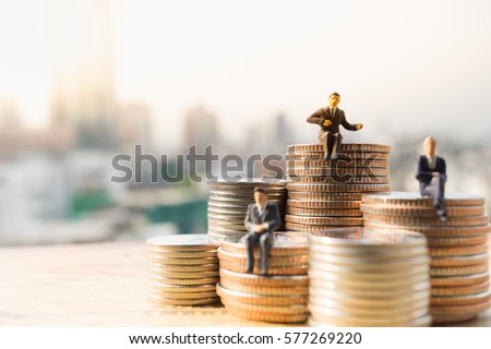 Miniature people: Small businessmen sitting on stack of coins, Money, Financial, Business Growth concept.