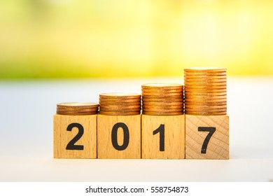 Miniature people and stack coins with wood block number 2017 using as background. business or new year concept - Shutterstock ID 558754873