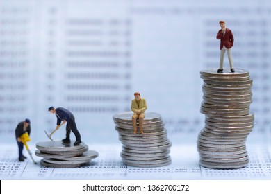 Miniature People Standing On A Pile Of Coins. Inequality And Social Class. Income And Economic Inequality Concept. Inequality In Social Class, Ideology, Gender, Racial And Ethnic And Health. 