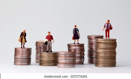 Miniature people standing on piles of different heights of coins. The growing concept of income gap. - Shutterstock ID 1072776341
